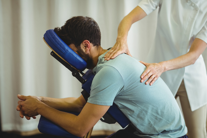 A man in a massage therapy session to relieve stress, tension and back pain.
