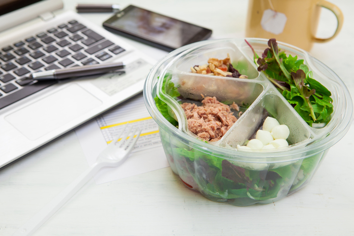 healthy homemade lunch sitting on work desk in front of laptop
