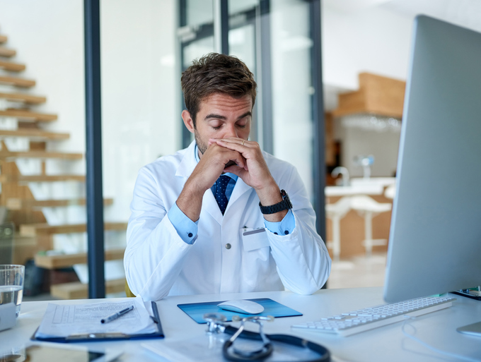 Physician burnout, a physician stressed at his desk